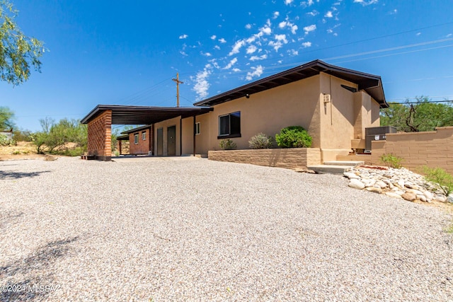 view of front of house featuring an attached carport and stucco siding