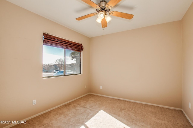 spare room with ceiling fan and light colored carpet