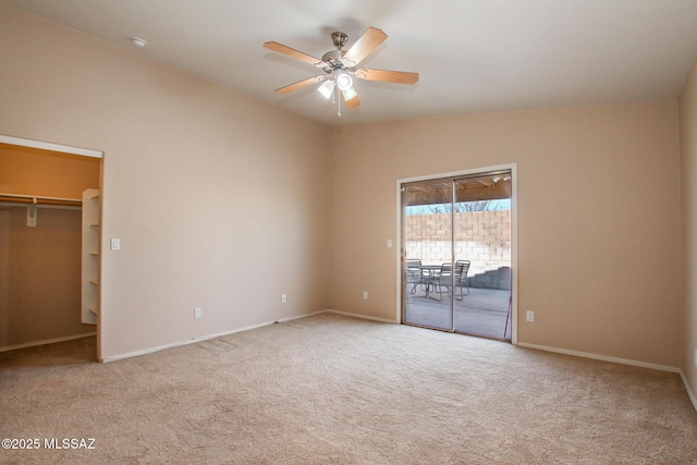 unfurnished bedroom featuring light carpet, ceiling fan, access to exterior, a walk in closet, and a closet