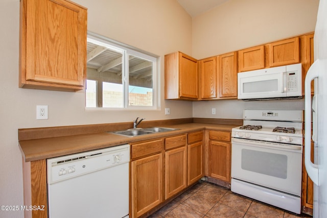 kitchen with sink, white appliances, and dark tile patterned floors