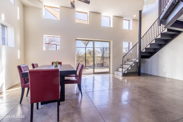 dining area with a towering ceiling and concrete floors