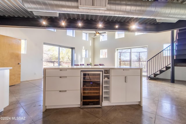 kitchen with white cabinets, ceiling fan, and wine cooler