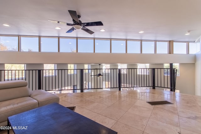 unfurnished living room featuring ceiling fan, a healthy amount of sunlight, and light tile patterned floors