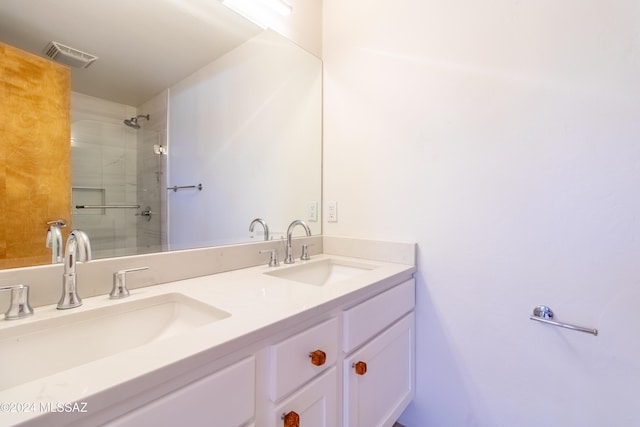 bathroom featuring a shower with door and vanity