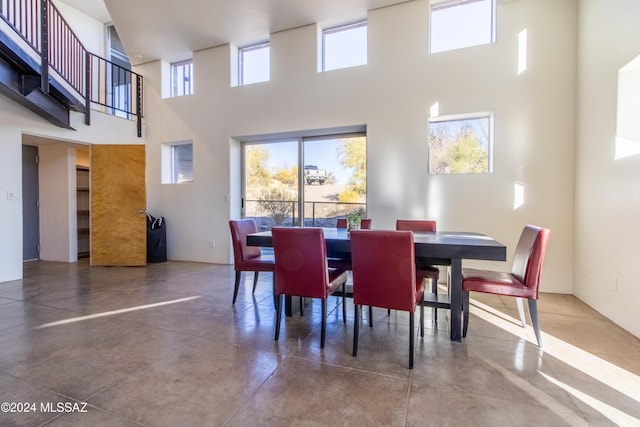 dining area with a towering ceiling and concrete floors