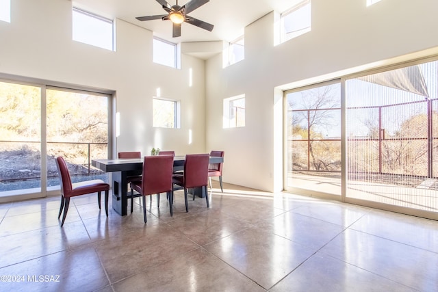 dining area featuring a high ceiling, ceiling fan, and a healthy amount of sunlight