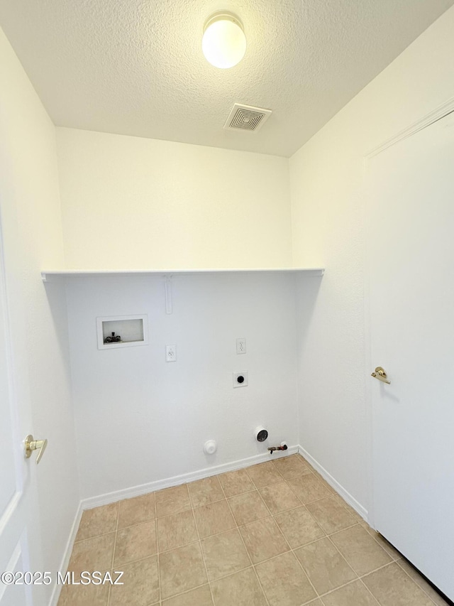 clothes washing area featuring a textured ceiling, hookup for an electric dryer, light tile patterned floors, hookup for a washing machine, and hookup for a gas dryer