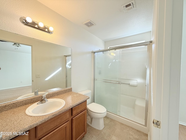 bathroom featuring toilet, an enclosed shower, a textured ceiling, and vanity