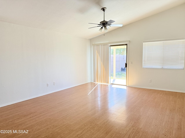 spare room with light wood finished floors, ceiling fan, baseboards, and vaulted ceiling