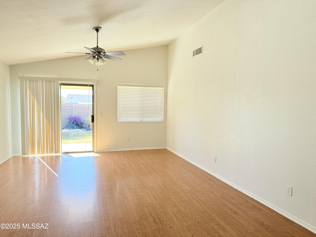 empty room with lofted ceiling, ceiling fan, and light hardwood / wood-style flooring