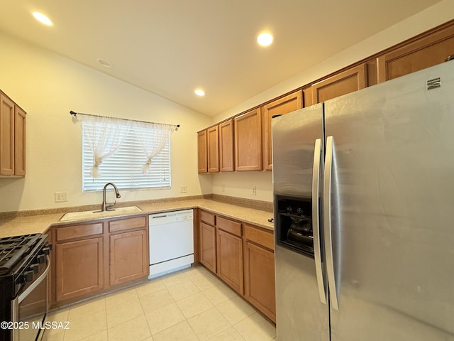 kitchen featuring gas range, dishwasher, vaulted ceiling, stainless steel fridge with ice dispenser, and sink