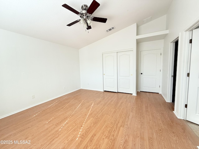 unfurnished bedroom with light hardwood / wood-style floors, a closet, ceiling fan, and vaulted ceiling