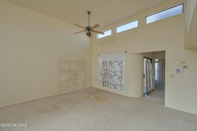 empty room with a high ceiling and ceiling fan