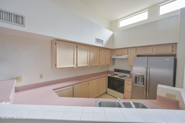 kitchen featuring white range with electric cooktop, stainless steel fridge with ice dispenser, tile countertops, and plenty of natural light