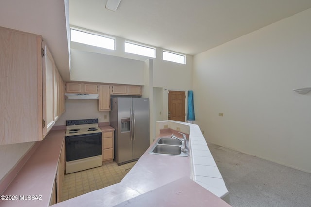 kitchen featuring light brown cabinets, a high ceiling, white electric range, sink, and stainless steel fridge with ice dispenser