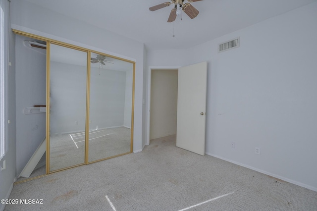 unfurnished bedroom with ceiling fan, a closet, and light colored carpet