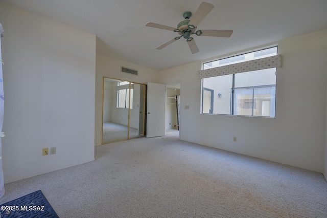 unfurnished bedroom with ceiling fan, a closet, and light colored carpet