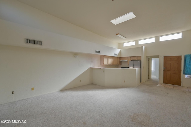 basement featuring light colored carpet and stainless steel refrigerator