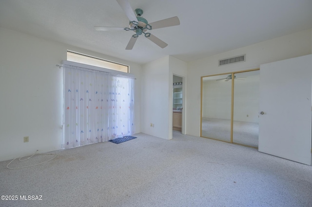 unfurnished bedroom with carpet, a closet, and ceiling fan