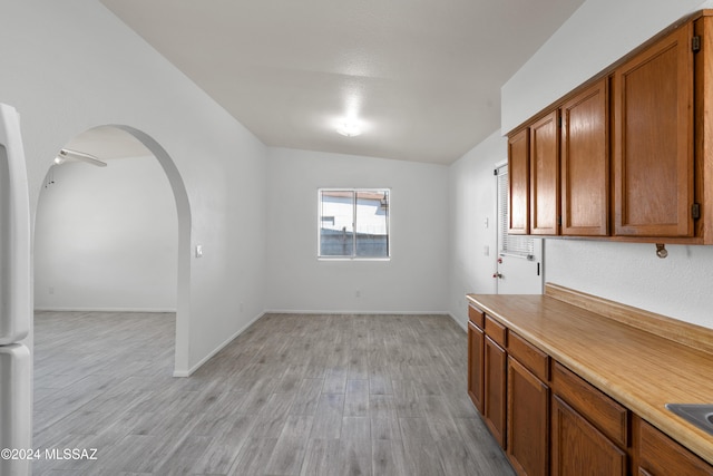 interior space with ceiling fan, light wood-type flooring, and vaulted ceiling