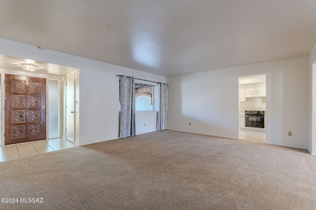 71 N Las Yucas, Green Valley, AZ 85614 - unfurnished living room featuring light carpet and light tile patterned floors