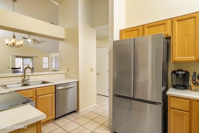 kitchen featuring sink, vaulted ceiling, light tile patterned floors, ceiling fan with notable chandelier, and appliances with stainless steel finishes