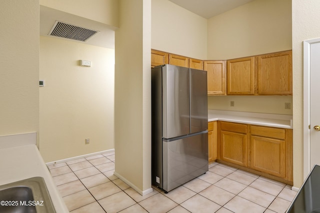 kitchen featuring stainless steel fridge and light tile patterned flooring