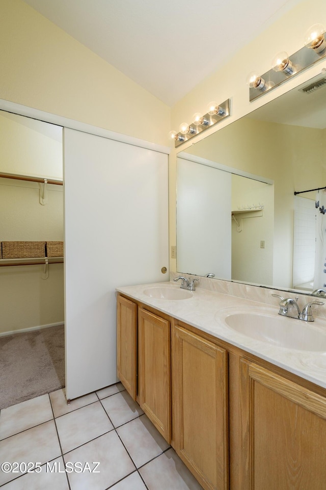 bathroom featuring tile patterned flooring, vanity, and lofted ceiling