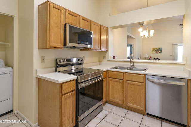 kitchen with sink, a chandelier, washer / dryer, light tile patterned floors, and appliances with stainless steel finishes