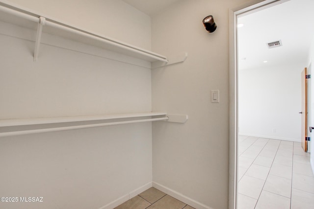 spacious closet with light tile patterned floors