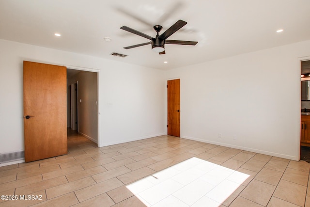 spare room featuring ceiling fan and light tile patterned flooring