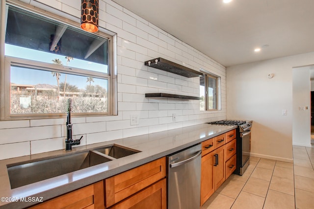 kitchen featuring backsplash, a healthy amount of sunlight, sink, and appliances with stainless steel finishes