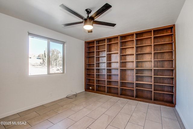 empty room featuring built in shelves and ceiling fan