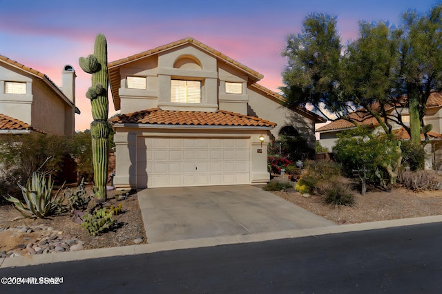 mediterranean / spanish-style home with a garage