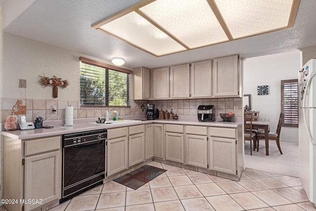 kitchen with decorative backsplash, sink, white refrigerator, black dishwasher, and light tile patterned flooring