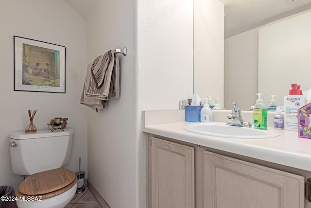 bathroom with tile patterned flooring, vanity, and toilet