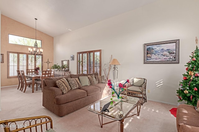 living room with a chandelier, light carpet, and high vaulted ceiling