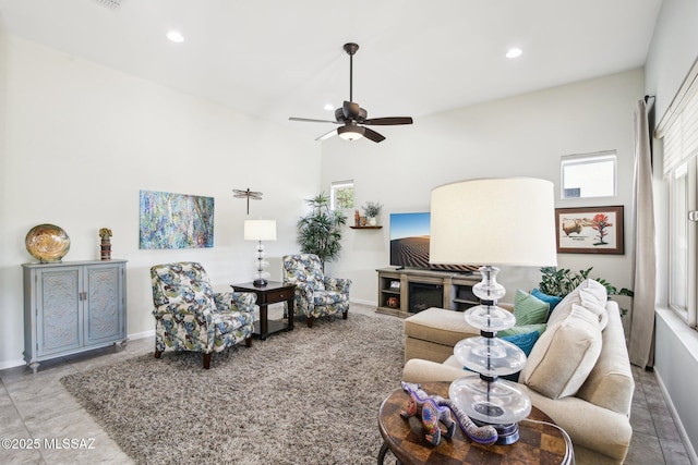 living room with ceiling fan and a fireplace