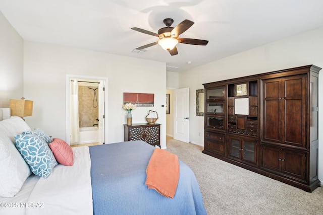 carpeted bedroom with ensuite bathroom and ceiling fan