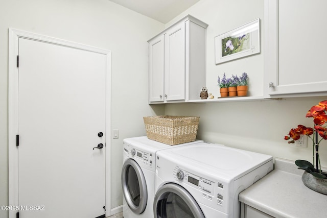 washroom featuring cabinets and washing machine and clothes dryer