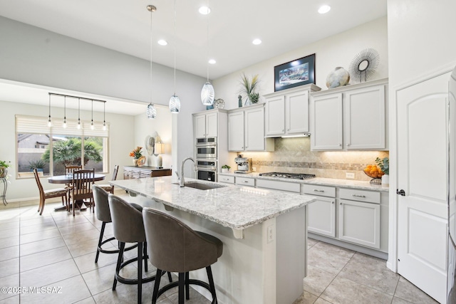 kitchen featuring white cabinets, an island with sink, pendant lighting, and appliances with stainless steel finishes