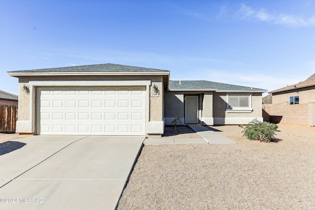 view of front of home with an attached garage, fence, concrete driveway, and stucco siding