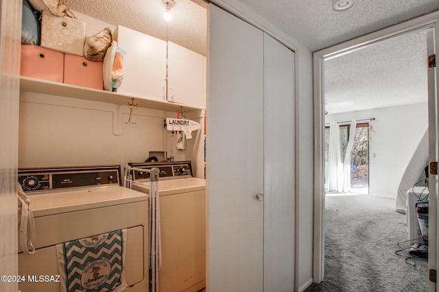 laundry area with cabinets, carpet floors, washer and dryer, and a textured ceiling