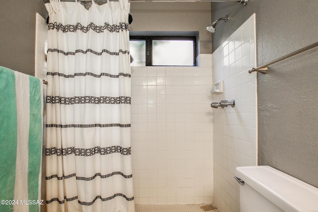 bathroom with a shower with curtain and toilet