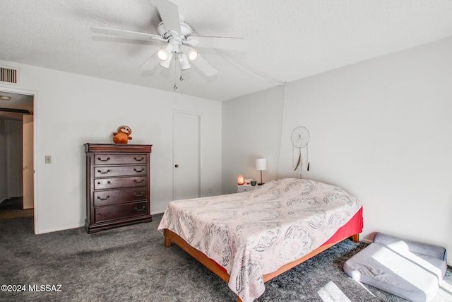 bedroom featuring dark colored carpet, ceiling fan, and a textured ceiling