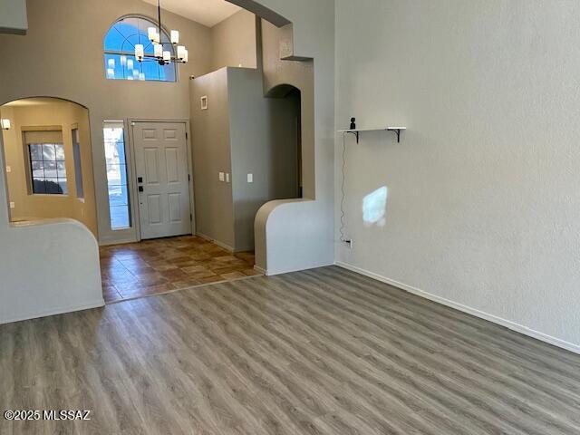 entrance foyer featuring a chandelier, hardwood / wood-style floors, and a high ceiling