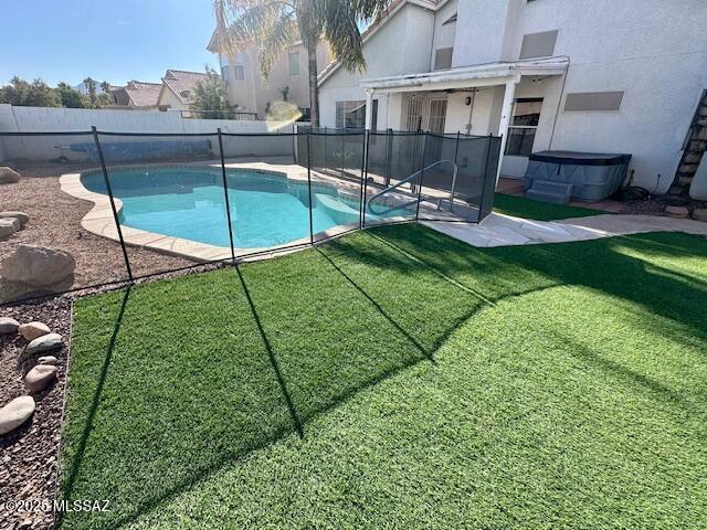 view of swimming pool with a jacuzzi, a yard, and a patio