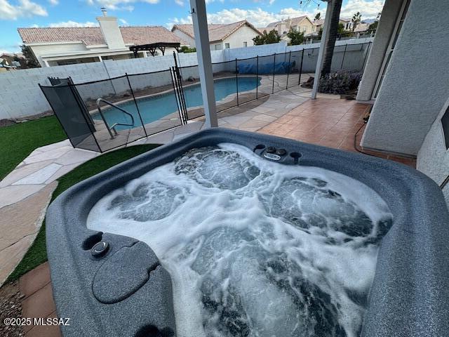 view of swimming pool featuring a patio and an outdoor hot tub