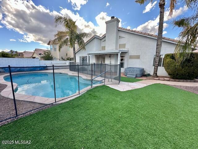 view of pool featuring a hot tub, a patio, and a lawn