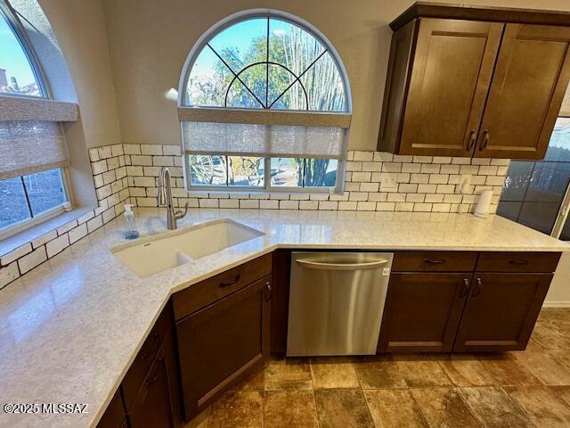 kitchen with tasteful backsplash, dishwasher, and sink